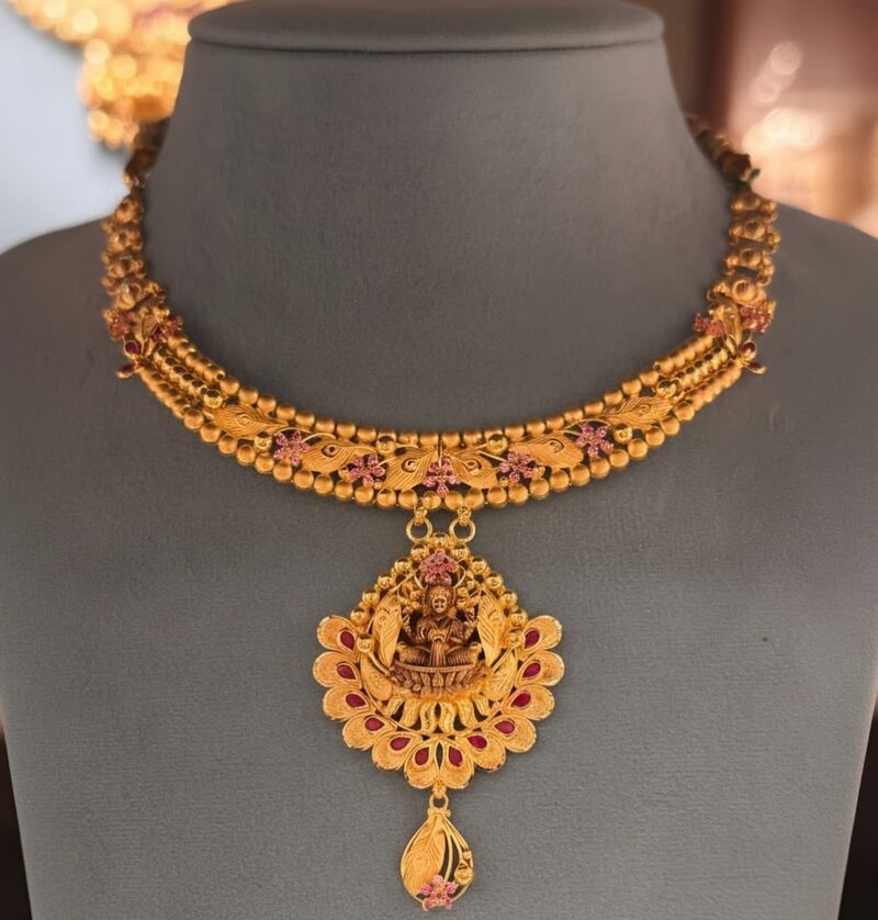 Gold choker necklace with ruby-set floral pendant and teardrop