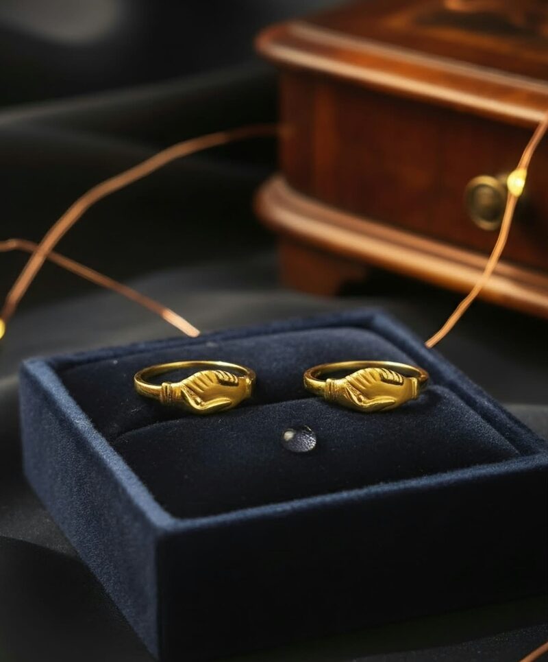 Pair of gold rings with clasped-hand motif