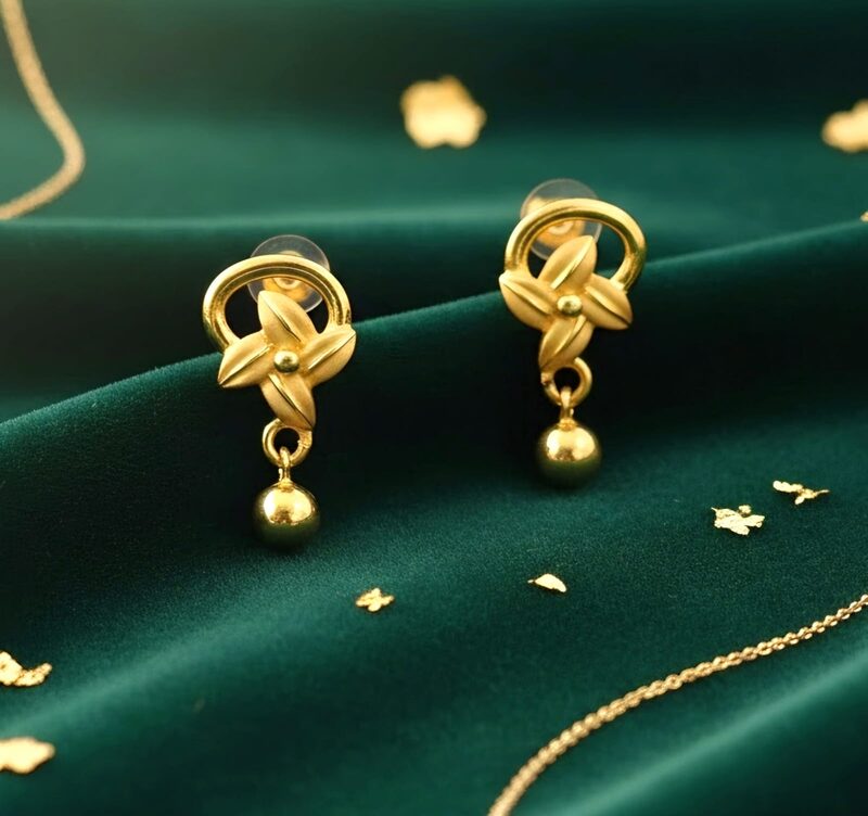Gold floral knot stud earrings with bead drop