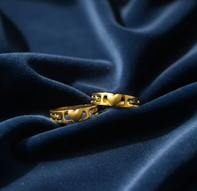Pair of gold band rings with heart cut-outs