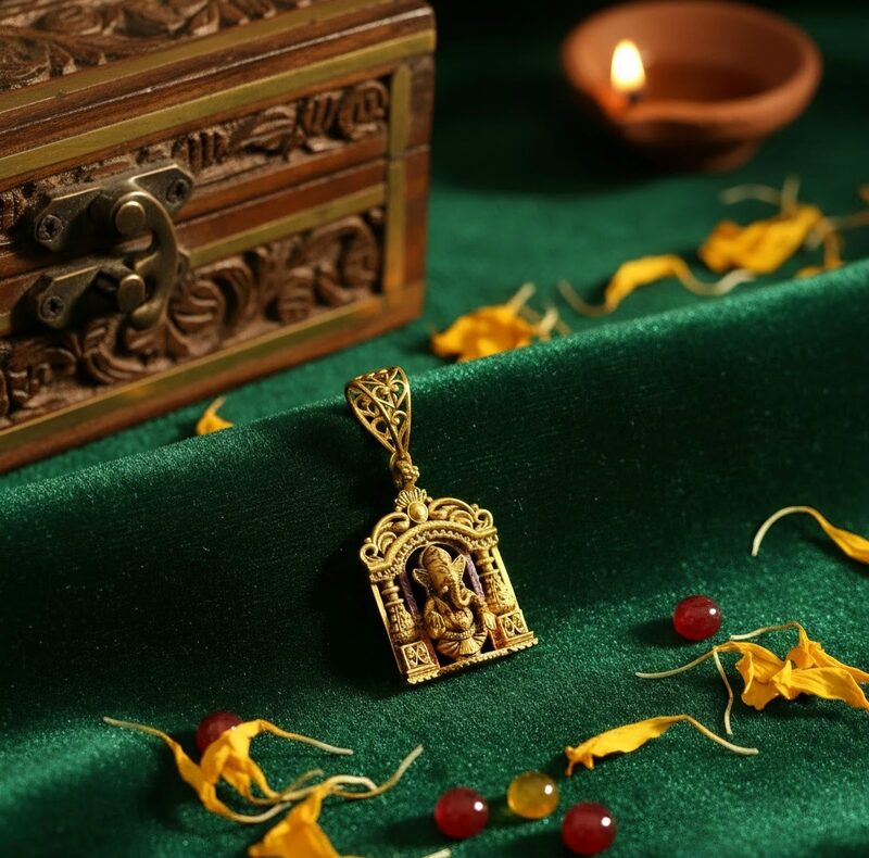 Gold temple pendant with deity in carved arch